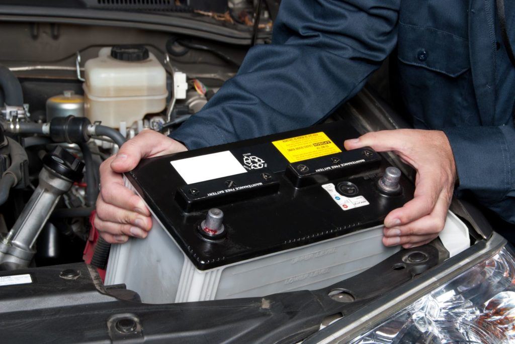 Mechanic installing a car battery (Optima Batteries - 2024 Buyers Guide)