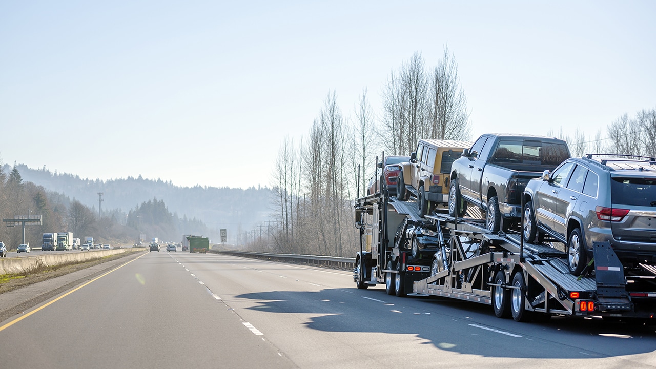 A car trailer used by car shipping companies travels down a highway.
