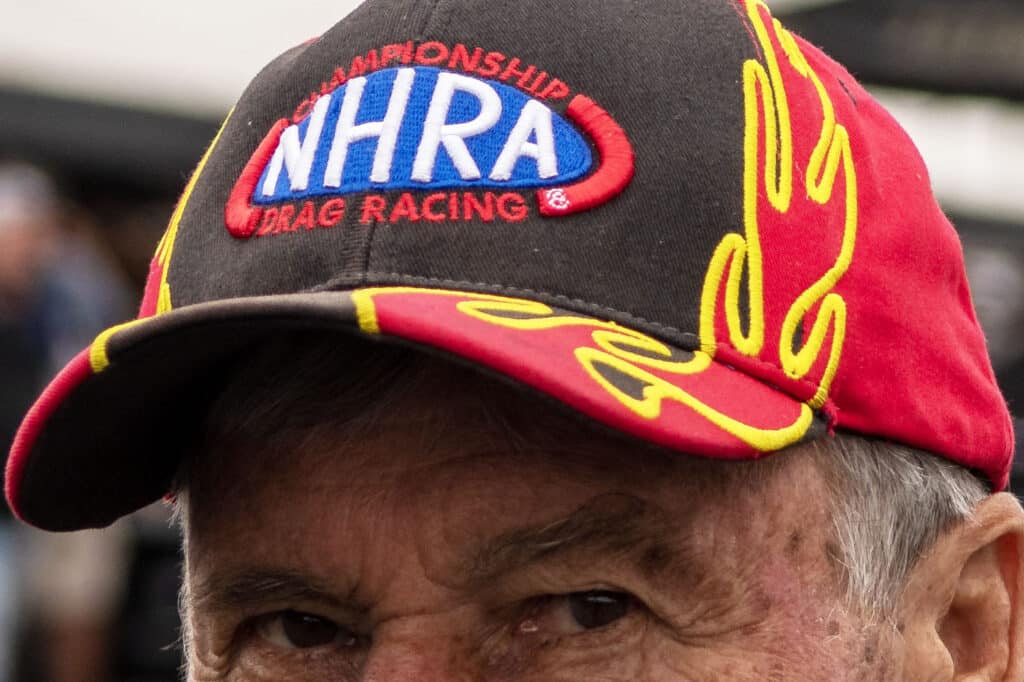 a racing fan wears an nhra hat with flames on the side