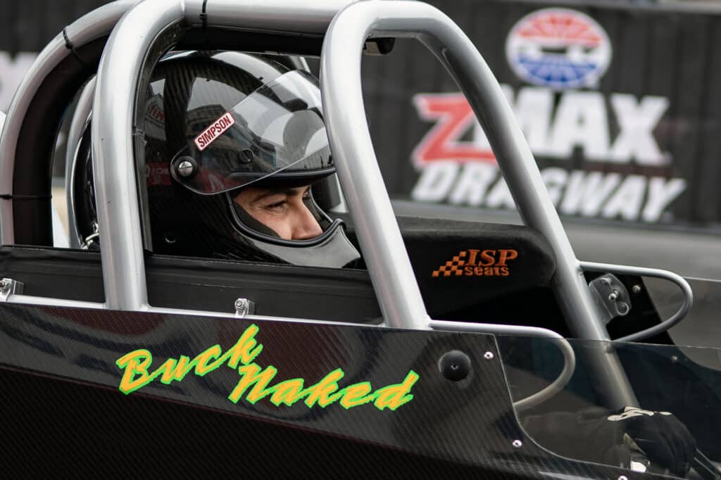 an nhra racer sitting in the cockpit of their black vehicle